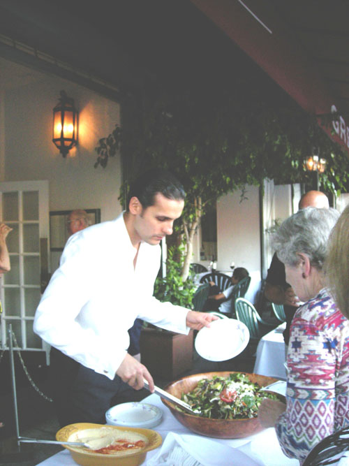 MEDITERRANEAN cuisine is on the menu at Le Petit Greek. Waiter dishes out a "taste" at a previous event.