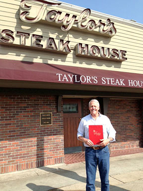 OWNER Bruce Taylor in front of the restaurant showing off its new signage.