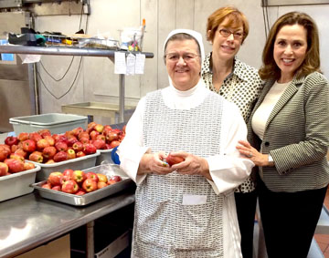 IN THE KITCHEN: Sister Alice Marie Quinn, Daryl Twerdahl and Gina Riberi at St. Vincent Meals on Wheels. Apples are added to cold supper meals and student lunches. 