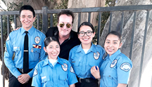 Event host Bill Devlin stands with cadets from the Wilshire Community Police Council. 