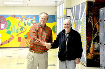 SHAKING HANDS in cooperation are teacher Kevin Glynn (left) and alumnus Ken Marsh (right). 
